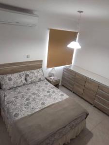 1 dormitorio con 1 cama, vestidor y lámpara en Confortable departamento con cochera, hasta 4 personas en San Juan