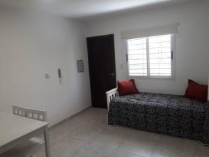 1 dormitorio con cama y ventana en Confortable departamento con cochera, hasta 4 personas en San Juan
