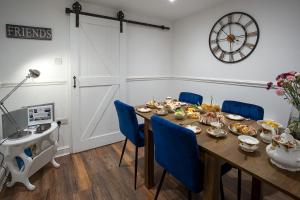 a dining room with a table and blue chairs at Wavecrest Cottage - Characterful 3 Bedroom Holiday Cottage in Flamborough