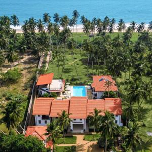 an aerial view of a resort with palm trees and the ocean at Green Parrot Hotel - ROOMS ONLY, NO MEALS in Tangalle