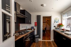 eine Küche mit Spüle und Herd oberen Backofen in der Unterkunft Wavecrest Retreat , Hot Tub & Garden, Sleeps 8 in Flamborough