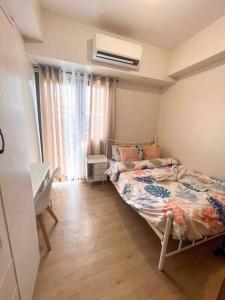 a bedroom with a bed and a desk in it at Fully furnished 1-BR Condo Unit at Spring Residences in Manila