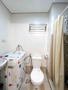a bathroom with a toilet and a sink at Fully furnished 1-BR Condo Unit at Spring Residences in Manila