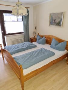 a bedroom with a large wooden bed with blue pillows at Bergdiamant in Garmisch-Partenkirchen