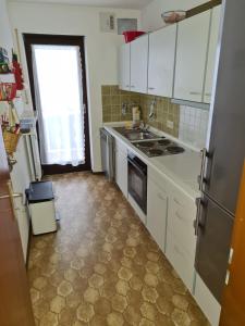 a kitchen with white cabinets and a sink and a window at Bergdiamant in Garmisch-Partenkirchen