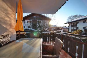 a table and chairs on a balcony with an umbrella at Bergdiamant in Garmisch-Partenkirchen