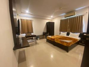 a bedroom with a bed and a chair in it at SHLOKA RESIDENCY in Shamshabad