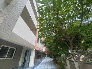 un edificio con un árbol al lado de una calle en SHLOKA RESIDENCY en Shamshabad