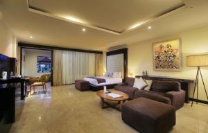 uma sala de estar com um sofá e uma cama em Sagara Villas and Suites Sanur em Sanur