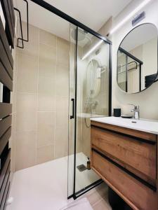 La salle de bains est pourvue d'une douche, d'un lavabo et d'un miroir. dans l'établissement IMMOGROOM - Total renovation 2023 - At the foot of the slopes - Wifi -, à Tignes
