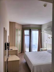 チェシメにあるRıdvan Hotelのベッドとテレビが備わるホテルルームです。