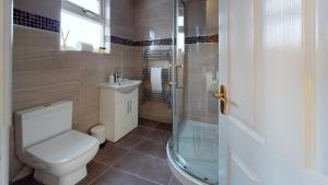a bathroom with a toilet and a glass shower at JDB Romford 5-Bedroom House with parking in Goodmayes