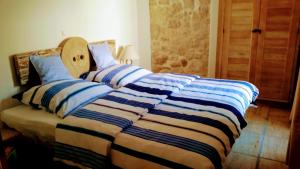 ein Bett mit einer gestreiften Bettdecke in einem Schlafzimmer in der Unterkunft Quartier No.63 in Ražanac