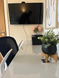 a table with a television and two plants on it at Pods of Kings Cross - 6 in London