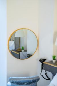 einen Spiegel an einer Wand mit einem blauen Stuhl und einem Tisch in der Unterkunft LUX 2 Bedrooms - 2 Bathrooms - F7 in London