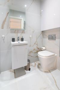 Baño blanco con aseo y lavamanos en LUX 2 Bedrooms - 2 Bathrooms - F7, en Londres