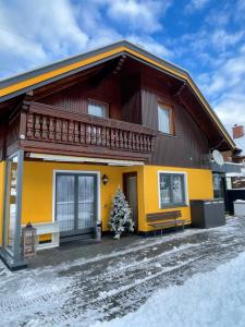 a yellow and red house in the snow at Sun Chalet in Schladming