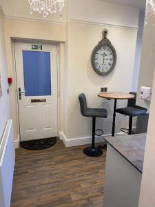 a waiting room with a clock on the wall and a door at The Fort Lytham St Annes in Lytham St Annes
