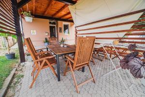 una mesa y sillas en un patio con sombrilla en Lux Living Apartments BUDIČ near Terme Čatež, en Brežice