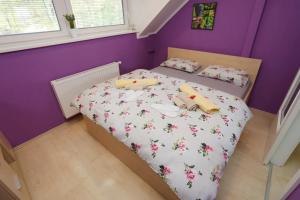 a small bedroom with a bed with flowers on it at Lux Living Apartments BUDIČ near Terme Čatež in Brežice