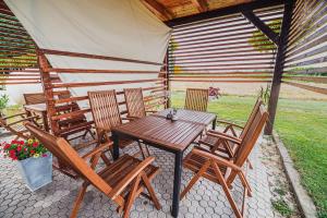 a wooden table and chairs on a patio at Lux Living Apartments BUDIČ near Terme Čatež in Brežice