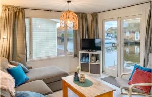 a living room with a couch and a tv at Chalet in Breukelen