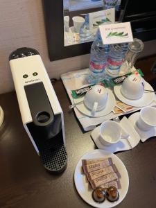 une table avec un téléphone portable et des plaques alimentaires dans l'établissement GM Royal Plaza, à Borovets