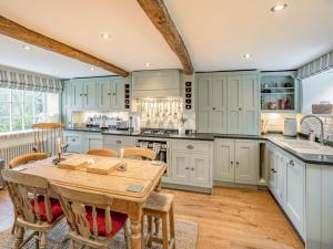 a kitchen with blue cabinets and a wooden table at Hob Cote in Heptonstall