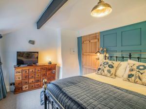 a bedroom with a bed and a dresser and a television at Hob Cote in Heptonstall