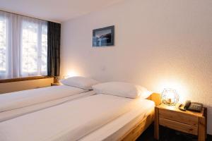 Letto o letti in una camera di Jungfrau Lodge, Swiss Mountain Hotel