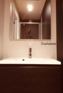 bagno con lavandino, specchio e lavandino di Dolce Vita - zonnig familie appartement met garagebox a Nieuwpoort