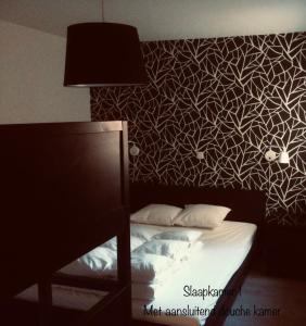 um quarto com uma cama com uma parede em preto e branco em Dolce Vita - zonnig familie appartement met garagebox em Nieuwpoort