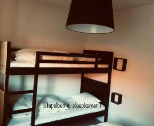 2 Etagenbetten in einem Zimmer mit einer Lampe in der Unterkunft Dolce Vita - zonnig familie appartement met garagebox in Nieuwpoort