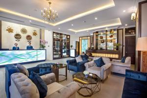 a living room with blue furniture and a large screen at Halina Hotel and Apartment in Da Nang