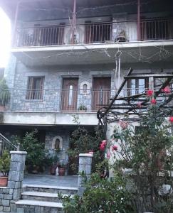 ein Gebäude mit einer Treppe und einem Balkon mit Blumen in der Unterkunft GERASIMOS HOYSE in Vitina