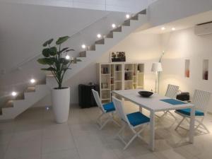 a dining room with a table and chairs and stairs at Villa Carabane in Somone