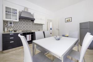 a kitchen with a white table and white chairs at Parsano Suite in Sorrento