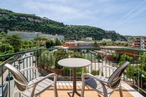 a balcony with a table and chairs overlooking a city at Parsano Suite in Sorrento