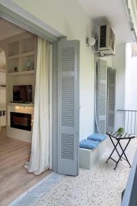 Cette chambre dispose de portes blanches, d'une table et d'un canapé. dans l'établissement Romantic apartment with hot tub next to Acropolis, à Athènes