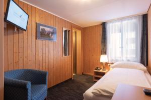 a hotel room with a bed and a tv at Jungfrau Lodge, Swiss Mountain Hotel in Grindelwald