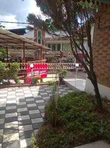 a patio with a red bench and a tree at Periyar Huts in Thekkady