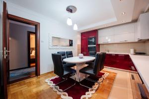a kitchen with a white table and black chairs at Loft2 in Kolašin +12 photos