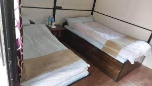 two beds in a room with towels on them at Bamby Chilling House in Sauraha