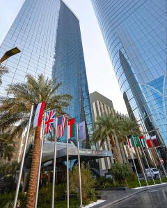 a group of flags in front of a tall building at AlHamra Hotel Kuwait in Kuwait