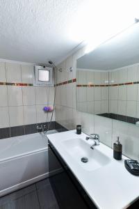 a bathroom with a sink and a tub and a mirror at Friendly Flat 1 in Edessa