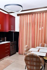 a kitchen with red cabinets and a table and chairs at Friendly Flat 1 in Edessa