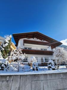a building covered in snow with trees in front of it at Haus Gabriele in Gaschurn