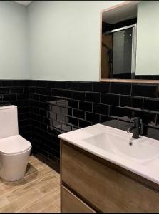 a bathroom with a sink and a toilet and a mirror at La Joya in Navalacruz