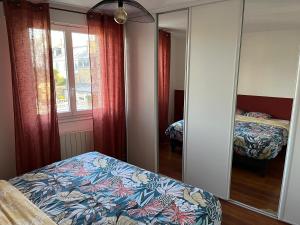 a bedroom with a mirror and a bed in it at Appartement quartier calme. Proche Port et plages. in Saint-Brieuc