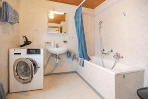a bathroom with a washing machine and a sink at Apartment Arabelle in Grindelwald